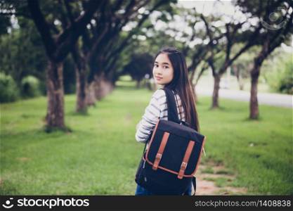 beautiful Asian girl student holding books and smiling at camera and learning and education concept on park in summer for relax time at sunset with a warm light