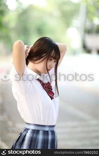 beautiful asian japanese school girl uniform looking at park outdoor