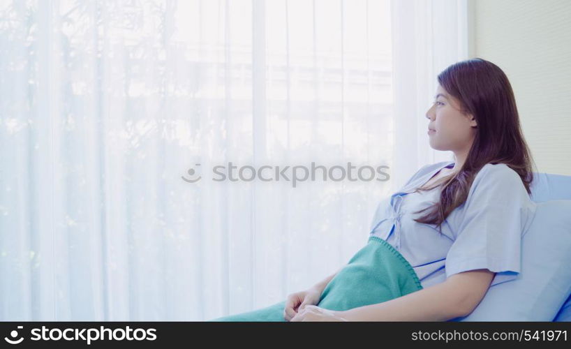 Beautiful Asian patient sick and sleeping while staying on Patient's bed at hospital. Medicine and health care concept.