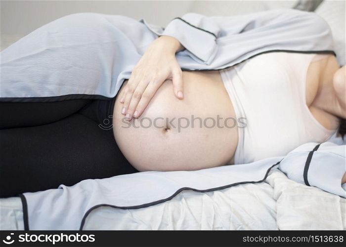 Beautiful asian pregnant woman is sleeping on bed