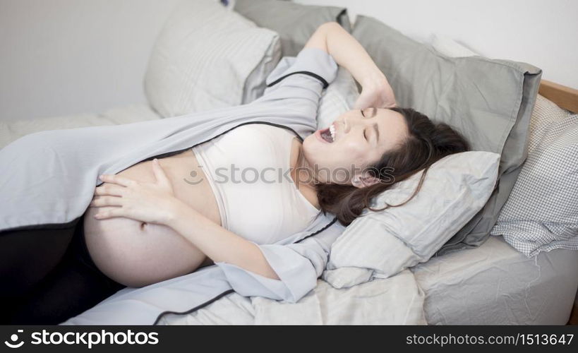 Beautiful asian pregnant woman is wake up