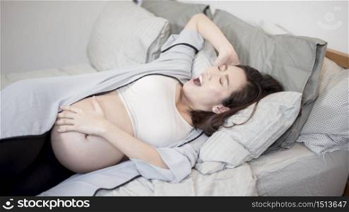 Beautiful asian pregnant woman is wake up