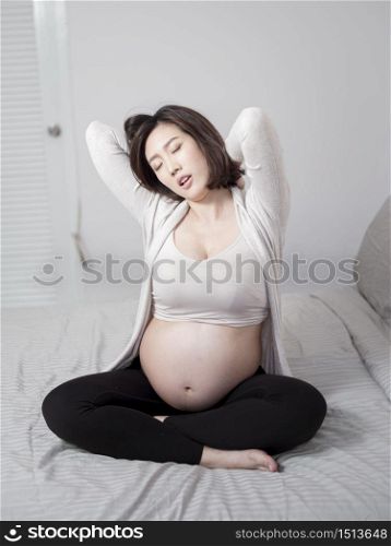Beautiful asian pregnant woman is wake up