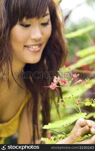 Beautiful asian smelling a flower