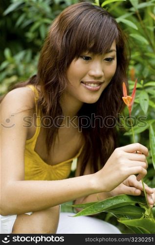 Beautiful asian smelling a flower