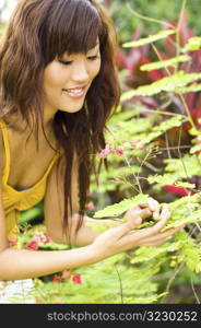 Beautiful asian smelling a flower