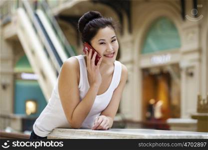 Beautiful asian talking on the mobile phone, indoor