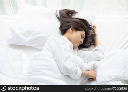 beautiful Asian woman basking and sleeping in white bed.