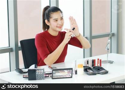 Beautiful Asian woman blogger recording on red smartphone for make up tutorial video in Cosmetics Vlog website. Youtber and Marketing in social media concept.
