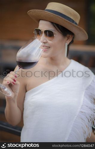 beautiful asian woman drinking red wine in wine glass