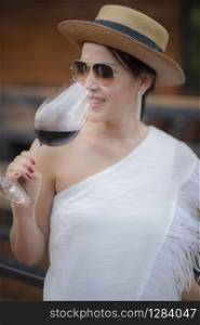 beautiful asian woman drinking red wine in wine glass