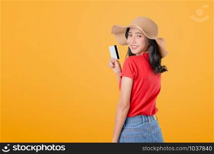 Beautiful Asian woman good skin holding credit card payment on orange background with copy space.