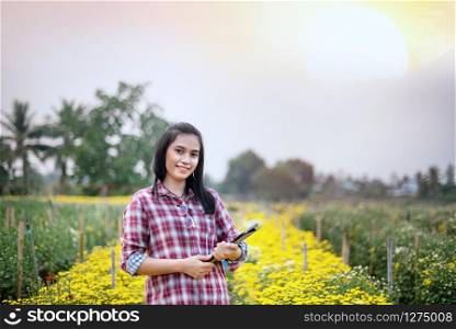 Beautiful asian woman holding bouquet flowers , Portrait in nature field. happy farmers