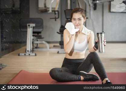 Beautiful asian woman is doing exercise in the gym