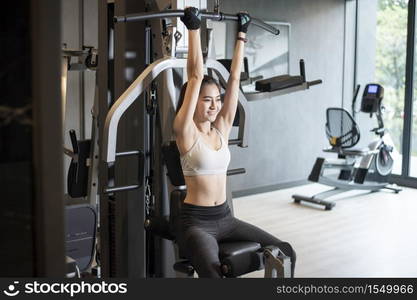 Beautiful asian woman is doing exercise in the gym