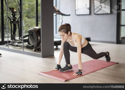 Beautiful asian woman is doing exercise in the gym