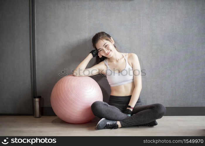 Beautiful asian woman is doing exercise in the gym