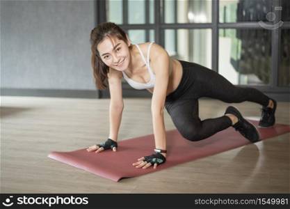Beautiful asian woman is doing exercise in the gym
