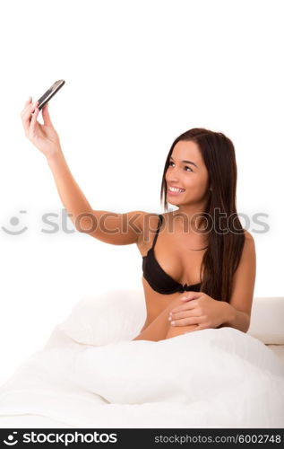Beautiful asian woman making a self portrait in bed with her cellphone