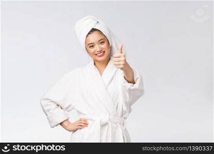 Beautiful asian woman perfect skin showing thumbs up isolated on white background. Beautiful asian woman perfect skin showing thumbs up isolated on white background.