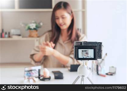 beautiful asian woman professional beauty vlog or blogger present cosmetics and applying make-up in front camera for recording video