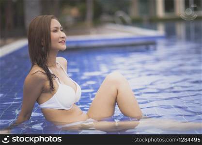 beautiful asian woman relaxing in blue water pool. beautiful asian woman relaxing in blue water pool