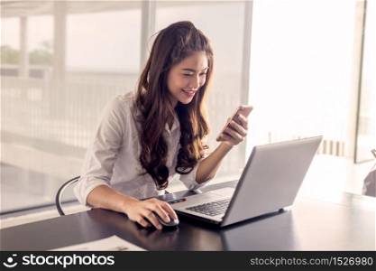 Beautiful Asian woman shopping online by laptop and smartphone,Warm tone