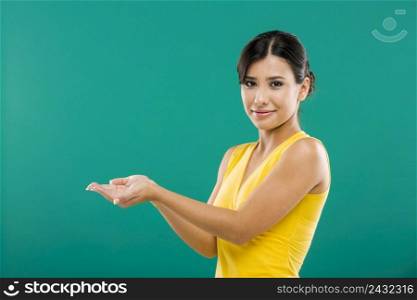 Beautiful asian woman showing the palm of the hands, over a green background