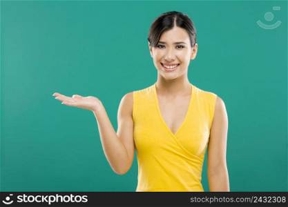 Beautiful asian woman showing the palm of the right hand, over a green background