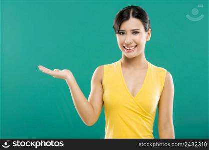 Beautiful asian woman showing the palm of the right hand, over a green background