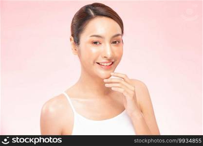 Beautiful Asian woman smile touching chin with clean and fresh skin Happiness and cheerful with positive emotional,isolated on pink background,Beauty Cosmetics and spa Treatment Concept