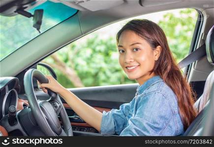 Beautiful Asian woman smiling and enjoying.driving a car on road for travel