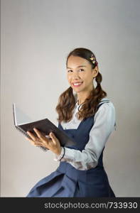 beautiful asian woman with her book in blue and white dress. beautiful asian woman