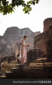 beautiful asian woman with pink lotus flower standing on ancient brick in ayutthay heritage place thailand