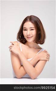 Beautiful Asian woman with short hair looking at camera smile with clean and fresh skin Happiness and cheerful with positive emotional,isolated on gray background,Beauty and Cosmetics Concept