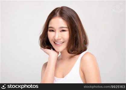Beautiful Asian woman with short hair looking at camera smile with clean and fresh skin Happiness and cheerful with positive emotional,isolated on gray background,Beauty and Cosmetics Concept