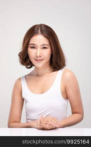 Beautiful Asian woman with short hair looking at camera smile with clean and fresh skin Happiness and cheerful with positive emotional,isolated on gray background,Beauty and Cosmetics Concept