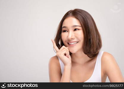 Beautiful Asian woman with short hair looking at camera smile with clean and fresh skin Happiness and cheerful with positive emotional,isolated on gray background,Beauty and Cosmetics Concept