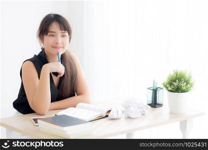 Beautiful asian woman writer smiling thinking idea writing on notebook diary with planning working on desk office, lifestyle asia girl have inspiration with success, education and business concept.