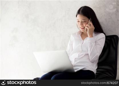 Beautiful asian young businesswoman excited and glad of success with laptop, girl taking mobile phone and working coffee shop on cement background, career freelance business concept.