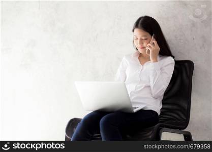 Beautiful asian young businesswoman excited and glad of success with laptop, girl taking mobile phone and working coffee shop on cement background, career freelance business concept.