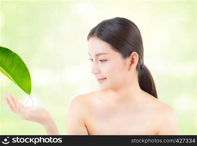 Beautiful asian young woman smile showing gesture hand holding drop water for leaf girl with presenting cosmetic natural of skincare on nature green background with copyspace beauty concept.