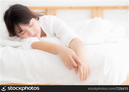 Beautiful asian young woman tired sleeping lying in bed comfortable and happy, girl with relax and leisure in the bedroom, health and wellness concept.