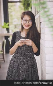 beautiful asian younger woman toothy smiling face happiness emotion with smartphone in hand