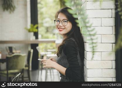 beautiful asian younger woman toothy smiling face happiness emotion with smartphone in hand