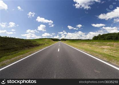 beautiful asphalt road. beautiful asphalt road with blue sky and mixed forest on the horizon, summer landscape with cloudy sky