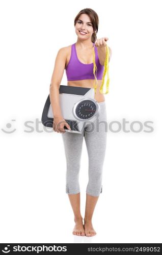 Beautiful athletic woman smilling and holding a scale and a measure tape, isolated on white
