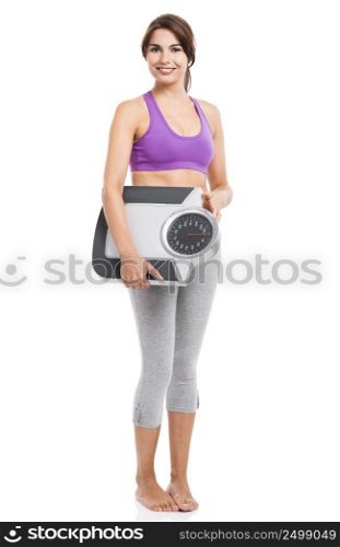 Beautiful athletic woman smilling and holding a scale, isolated on white