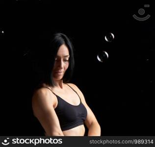 beautiful athletic woman with muscular body dressed with a black topic, sad woman face