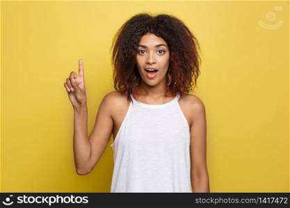 Beautiful attractive African American woman with curly afro hair thinking of something. Yellow studio background. Copy Space. Beautiful attractive African American woman with curly afro hair thinking of something. Yellow studio background. Copy Space.